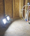 20,000 Lumen Dual Head LED Work Light With Adjustable Tripod illuminating construction site walls and floor