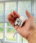 Heavy Duty Low Profile Metal Cord Tilter For 2 Inch Blinds held in hand, showcasing white resin and steel components.