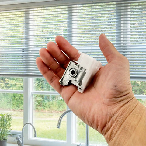 Heavy Duty Low Profile Metal Cord Tilter For 2 Inch Blinds held in hand, showcasing white resin and steel components.