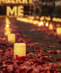 Remote Control Flameless Votive Candles 12 Pack Flickering Battery Operated LED Tealight Candles For Cozy Wedding And Christmas Decor Amber Yellow Batteries Included glowing among rose petals