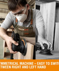 Woodworker using a powerful random orbital sander with brushless motor, 5 and 6 inch pads, central vacuum dust collection on wood panel.