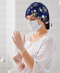 Nurse wearing floral 8 Pack Women's Scrub Caps With Buttons In Eight Different Patterns Adjustable Bouffant Surgical Hat with gloves