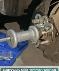 Close-up of Slide Hammer Puller Set 19 Piece With Front Wheel Hub Bearing Remover mounted on a vehicle axle for repair.