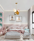 Modern Colorful Glass Pendant Lights With Gold Globe Finish in a pastel kids' room, featuring pink, orange, white, smoke gray shades.
