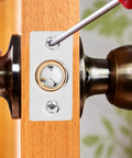 Adjustable Ball Catch Door Hardware In Silver Finish For Wood And Room Doors being installed on a wooden door with screwdriver.
