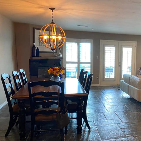 Dining room with Six-Light Orb Chandelier, 23.62-Inch Rustic Farmhouse Lighting In Stardust Finish over wooden table.