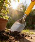 Nine Inch Serrated Edge Weeding Trowel with Stainless Steel Blade and Comfy Grip Handle digging in soil near a terracotta pot