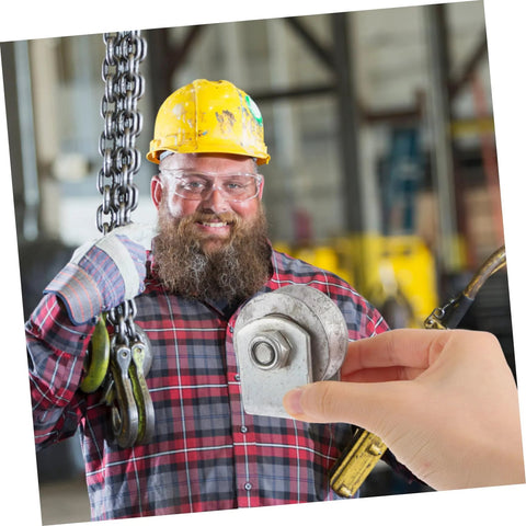 Cast iron V-type groove wheel roller for garage doors or gates, held by hand; worker in yellow hard hat.