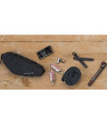Outpost Corner Bike Bag with Built In Pockets For Gear No Seatpost Rattle Slim Frame Organizer with tools and essentials on wood surface.