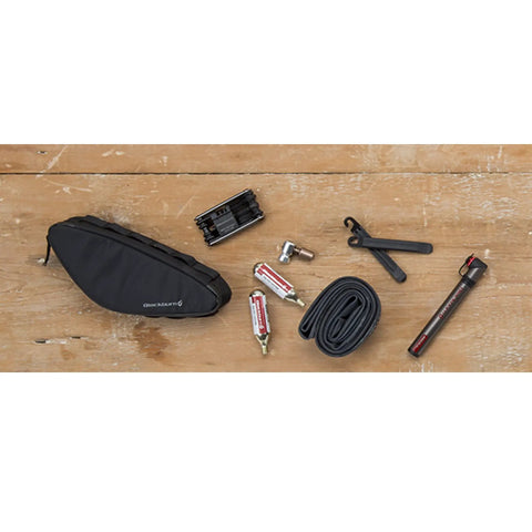 Outpost Corner Bike Bag with Built In Pockets For Gear No Seatpost Rattle Slim Frame Organizer with tools and essentials on wood surface.