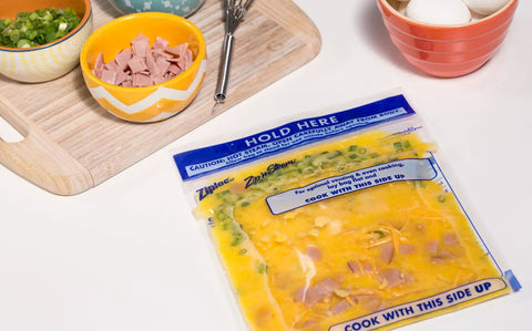 Zip N Steam Microwave Safe Food Storage Bag with ingredients on a cutting board, ready for meal prep