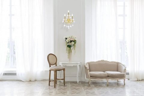 Royal Cut Clear Maria Theresa 3 Light Crystal Wall Sconce In Chrome Finish illuminating a bright living room with elegant decor.