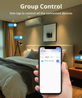 Hand holding phone with app showing 4 Pack S31 WiFi Smart Plug With Energy Monitoring and 15A Outlet in bedroom setting
