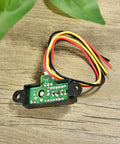 Sharp IR Analog Distance Sensor GP2Y0A21YK0F with wires shown on a wooden surface used in Arduino projects and robotics.