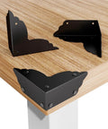 Top Notch Eight Piece Antique Bronze Corner Protectors, 70x70x26 mm, metal edge guards on wooden table corners.