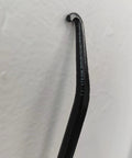 Close-up of black rubber-coated motorcycle exhaust spring puller hook