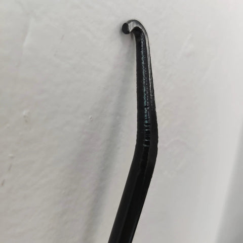 Close-up of black rubber-coated motorcycle exhaust spring puller hook