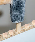 Hammer securing tapered wood plugs for screw holes with button plug head in furniture, lightweight repair caps for DIY projects.