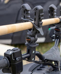 Rhino Grip XL Rack And Handlebar Mount for ATV with gear holder attached holding a wooden handle, close-up view.