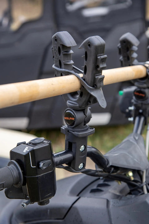 Rhino Grip XL Rack And Handlebar Mount for ATV with gear holder attached holding a wooden handle, close-up view.
