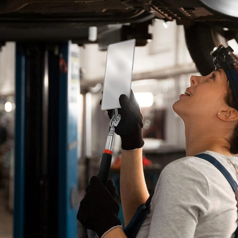 Mechanic using Telescoping Rectangular Inspection Mirror With 360 Degree Rotation for underbody vehicle check in a garage
