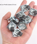 Hand holding eight 0.5 Inch Mini Swivel Caster Wheels with Self Adhesive Plate Low Profile Rubber Casters for Furniture and Small Kitchen Appliances