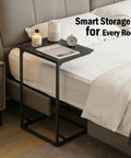 C Shaped End Table That Slides Under Sofa For Small Spaces beside bed with clock and candle on top, black steel frame