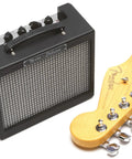 MD 20 Mini Deluxe Guitar Amp Bundle With Power Supply, Instrument Cable, Picks and Road Ready Portable Practice Amp next to guitar neck
