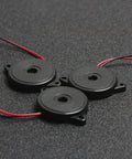 Three Enclosed Piezo Buzzer Alarm 95 DB With Wires, 30mm, Pack Of 5, displayed on a dark surface showing mounting holes.