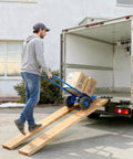 Man using Beefed Up Heavy Duty Steel Ramp Top Kit for 2x8 boards to load boxes into truck with a dolly
