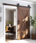 Installed Heavy Duty Sliding Barn Door Hardware Kit in Black with Industrial Wheel Hangers, Includes Pull Handle Set and Floor Guide.