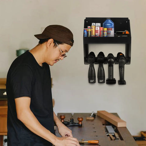 Man working in a workshop with a wall mount power tool organizer five drill holder rack heavy duty cordless drill storage rack in view.