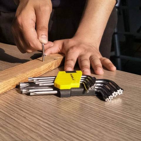 Person using Beefy 9 Piece Torx And Allen Wrench Set with Short Arm Hex Keys T10 to T50 on wooden board, chrome vanadium
