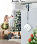 Smart Thermometer Hygrometer With WiFi And App Alerts hanging near a Christmas tree and gifts, ideal for home monitoring.