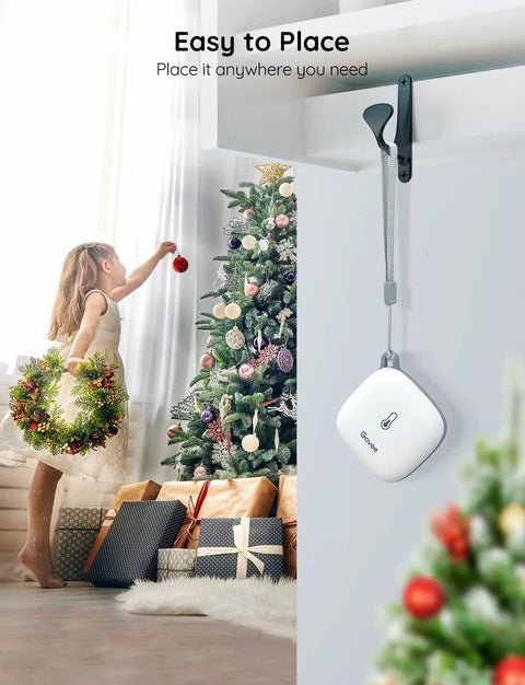 Smart Thermometer Hygrometer With WiFi And App Alerts hanging near a Christmas tree and gifts, ideal for home monitoring.