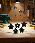 Five Pack Black Star Knobs For T Track Bolts And Feather Boards, 5/16-18 Female Thread, displayed on a woodworking bench.