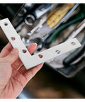 Hand holding Heavy Duty Stainless Steel L Shaped Corner Braces For Wood Panels And Shelves, 90 Degree Metal Mending Plates, 2x2x2 Inch