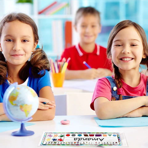Children in classroom using 36 Piece Set Of Upgraded Clear Self Adhesive Nameplate Pockets 15.3 By 4.5 Inch Desk Name Tags