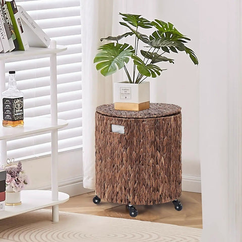 Round Water Hyacinth Storage Basket With Lid And Wheels boho chic, in a living room, with a plant on top, rattan bin with metal frame.