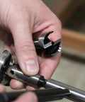 Hand holding a Premium Four Piece Forstner Bit Set, showing bit attachment and accurate design for splinter free cuts.