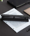 Three Hole Punch For Office And Home Use No Fuss Ten Sheets Puncher with durable metal construction in black finish on paper