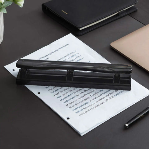 Three Hole Punch For Office And Home Use No Fuss Ten Sheets Puncher with durable metal construction in black finish on paper