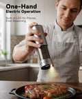 Person using Rechargeable Electric Salt And Pepper Grinder Set With LED Display seasoning steak on kitchen worktop.