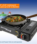 Dual Fuel Gas Camping Stove for Butane or Propane with Regulator Hose, Single Burner cooking vegetables in a frying pan.