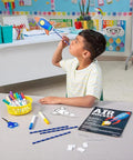 Color Your Own Air Rocket Craft Kit For Kids Ages 4 8 And Ten DIY Space Rockets STEM Fun That Totally Rocks Hands On And Creative Includes Pre Cut Cards Foam Shapes Pipettes And Straws Perfect Gift For Boys And Girls. Child holding a colored paper rocket craft in classroom
