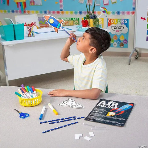 Color Your Own Air Rocket Craft Kit For Kids Ages 4 8 And Ten DIY Space Rockets STEM Fun That Totally Rocks Hands On And Creative Includes Pre Cut Cards Foam Shapes Pipettes And Straws Perfect Gift For Boys And Girls. Child holding a colored paper rocket craft in classroom