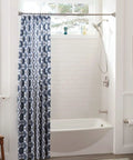Modern bathroom with blue patterned shower curtain in white tiled bathtub and brushed nickel accessories.