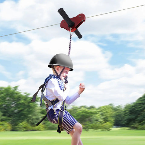Child riding Backyard Zip Line Kit For Kids And Adults, 120 Foot Outdoor Zipline With Swing Seat, Spring Brake, Safety Harness