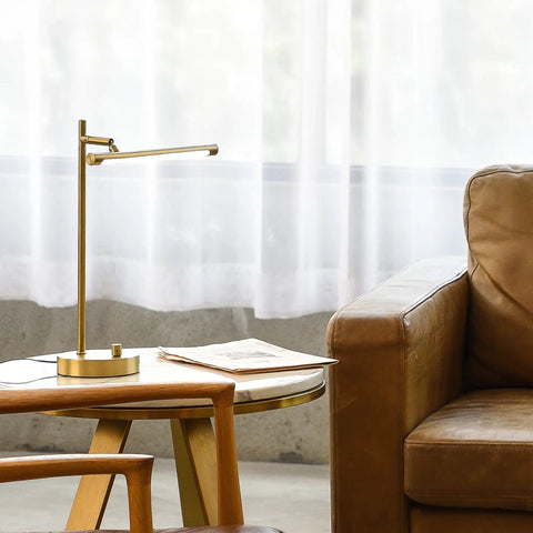 West 15 Inch LED Integrated Desk Lamp in Matte Brass with pivoting head on side table, near sofa