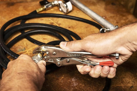 Person using 7-inch Curved Jaw Locking Pliers With Wire Cutter Set For Home DIY And Pros on cable, demonstrating heavy-duty grip.